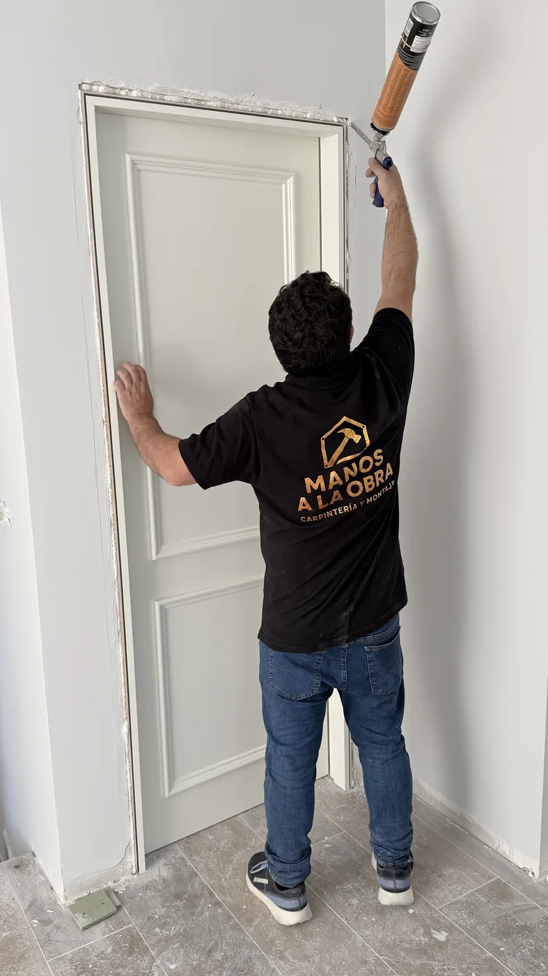 Carpintero de Manos a la Obra instalando una puerta de madera en Madrid